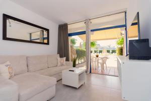 sala de estar con sofá, TV y patio en Riviera Peace en Mogán