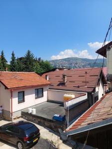 um carro estacionado em frente a uma casa com telhados em Hostel Bobito em Sarajevo