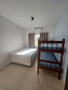 a small bedroom with a bed and a shelf at Casa Aconchego - piscina com hidromassagem in Guaratuba