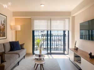 a living room with a couch and a large window at Alta by Wynwood House in Lima