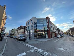 een gebouw in een stadsstraat met auto's op straat bij Apartament II w Centrum - Winda - 50 metrów od Starego Rynku in Kościerzyna