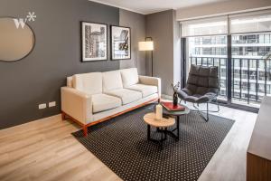 a living room with a white couch and a chair at Alta by Wynwood House in Lima