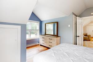 a bedroom with blue walls and a bed and a mirror at Spruce in Bethel