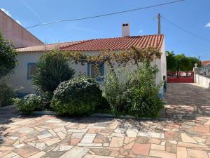 a house with a stone driveway in front of it at Casa dos Pécoxinhos in Arcos