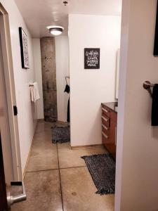 a hallway leading to a bathroom with a walk in shower at Staycation City Loft Free Gated Parking in Saint Louis