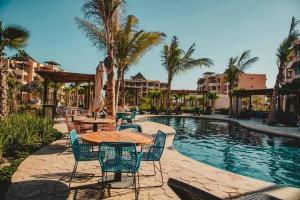 a patio with a table and chairs next to a pool at Departamento Altata Punta Paraiso in Altata