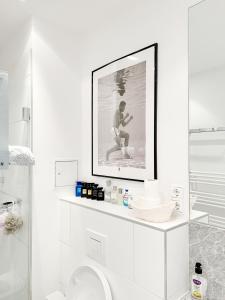 a bathroom with a picture of a man sitting on a shelf at Prime Comfort Apartment with Balcony & Free Parking in Berlin