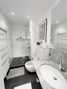 a bathroom with a sink and a toilet and a shower at Prime Comfort Apartment with Balcony & Free Parking in Berlin