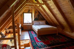 a bedroom with a bed in a wooden attic at Etno vodenica Ćirović - Ethno Watermill in Pljevlja