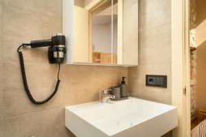 a bathroom with a sink and a phone on the wall at Apartamentos Calle Mayor 23 Llanes in Llanes