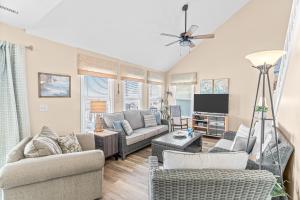 a living room with two couches and a tv at Blue View in Holden Beach