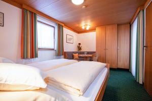 a hotel room with three beds and a table at Alpenblick in Reit im Winkl