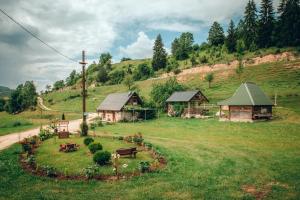 a group of buildings in a field with a hill at Etno vodenica Ćirović - Ethno Watermill in Pljevlja