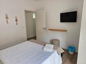 Schlafzimmer mit einem Bett und einem Flachbild-TV in der Unterkunft Curtido House Suits - Suite in Ílhavo