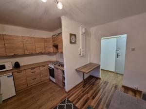 eine Küche mit Holzschränken und einem Tisch darin in der Unterkunft Apartament 41 in Częstochowa
