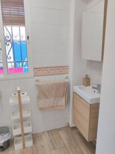 La salle de bains blanche est pourvue d'un lavabo et d'un miroir. dans l'établissement Lolas Cozy Studio, à Grenade