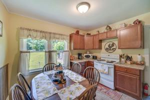 a kitchen with a table and chairs and a stove and sink at Grandmas Farm House on 125 Acres with Fire Pit! in Beattyville
