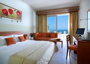 una camera con letto, scrivania e divano di Bali Beach and Sofia Village a Balíon