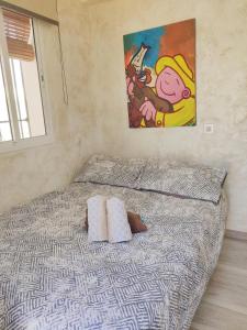 - un lit avec deux oreillers et un tableau mural dans l'établissement Lolas Cozy Studio, à Grenade