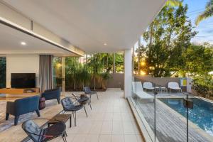 an outdoor patio with chairs and a swimming pool at 1 215 Gympie Terrace Noosaville in Noosaville