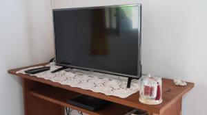 a flat screen tv sitting on a wooden stand at Ti Cannelle in Sainte-Luce