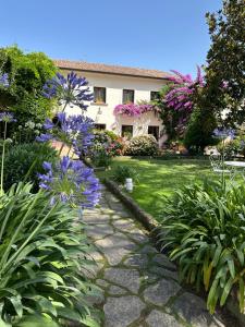 un jardín con flores púrpuras y una casa en Il Casale di Riardo Luxury B&B, en Riardo