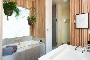 uma casa de banho com banheira e uma janela com plantas em ChampaHouse- Easy access to Rino/Ballpark/Downtown em Denver