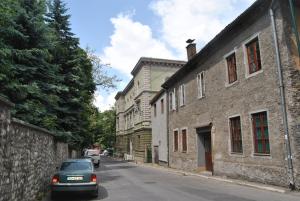 a car parked on a street next to an old building at Konak Apartment in Sarajevo