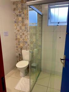 a bathroom with a toilet and a glass shower at Pousada Vila Catarina in Ouro Preto