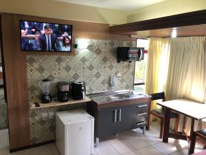 a kitchen with a tv hanging on the wall at Royal Service Hotel - Tambaú - ap 111 in João Pessoa