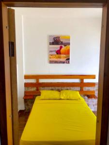 una camera con un grande letto giallo di COLIBRI GUEST HOUSE a Puerto López
