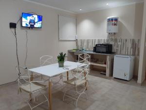 a kitchen with a table and chairs and a tv at El Solar Departamentos Tartagal in Tartagal
