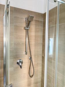 a shower with a shower head in a bathroom at Appartamento Bolzano Centro Talvera in Bolzano