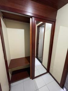 Manos Flat Tambaú - ap 111 في جواو بيسوا: خزانة ملابس مع أبواب مرآة في الغرفة