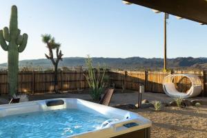 a hot tub in a yard with a cactus at Peaceful Desert Paradise - Casa Coyote in Joshua Tree