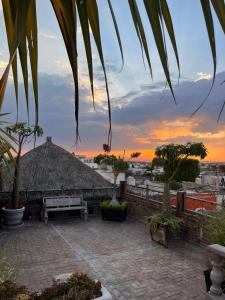 a building with a bench and a sunset in the background at Hotel Casa Carmona in Querétaro