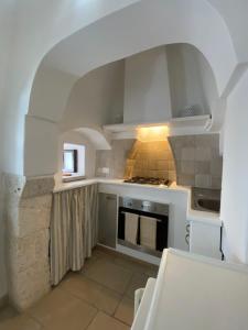 una cucina bianca con piano cottura e forno a microonde di Sav40 a Ostuni