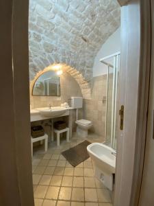 Un baño con lavabo, inodoro y espejo. en Sav40, en Ostuni 10 fotos más