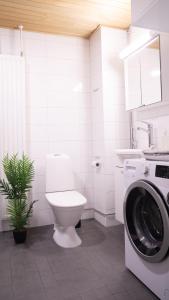 a bathroom with a toilet and a washing machine at Lovely 2R apartment in Oulu