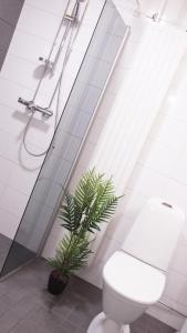 a bathroom with a toilet and a plant in it at Lovely 2R apartment in Oulu