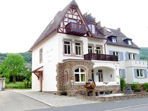 een groot wit huis met een balkon in een straat bij Alkener Villa in Alken