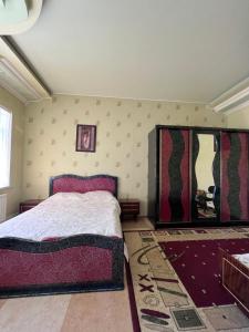 1 dormitorio con cama y pared con espejo en EMILI GUEST HOUSE, en Gyumri