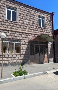 un edificio de ladrillo con una gran puerta y una puerta en EMILI GUEST HOUSE, en Gyumri
