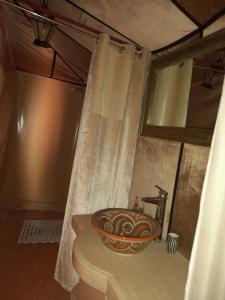 a bathroom with a sink with a shower curtain at Merzouga Highdune Camp With Heated Tents in Merzouga