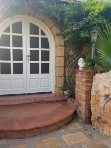 une porte blanche avec une passerelle en briques à côté d'un mur en briques dans l'établissement Villa Sofia, à Lampedusa