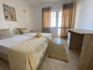 - une chambre avec 2 lits et une commode dans l'établissement Moradia Olival- BBQ, 2 Quartos, Quintal, à Albufeira