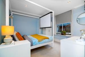 a white bedroom with a bed and a mirror at Double room w/Projector & Garden Hot Tub in London