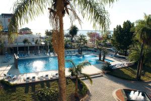 uma vista sobre uma piscina de resort com uma palmeira em Turismo Hotel Casino em Corrientes
