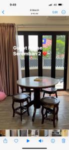 a table and two chairs in a room with a window at Rumah Tamu Sonata in Seremban