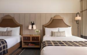 ein Hotelzimmer mit 2 Betten und einem Beistelltisch in der Unterkunft Estancia La Jolla Hotel & Spa in San Diego